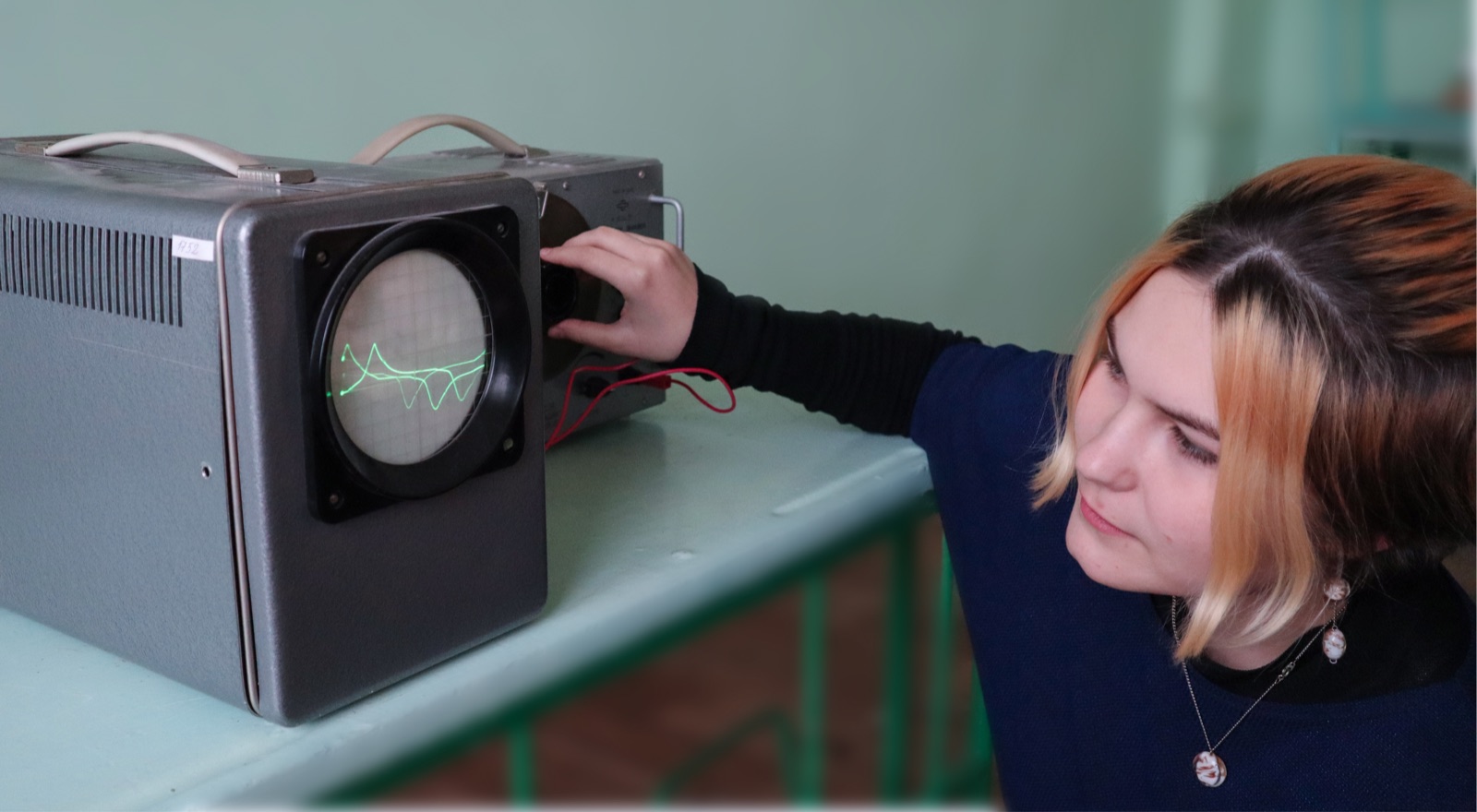 A student explores sound waves with classroom equipment.